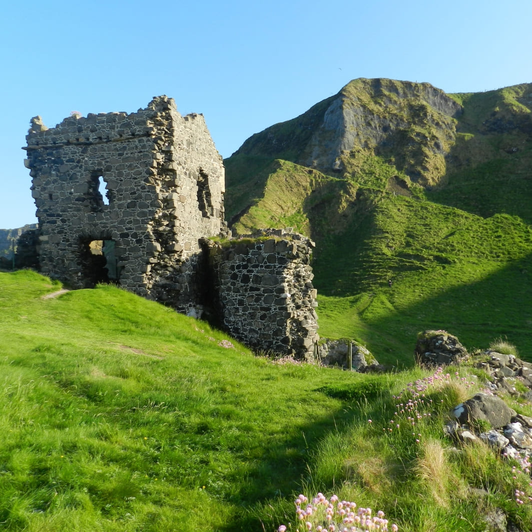 Ruined fortress on a green hill with ocean views in Ireland.