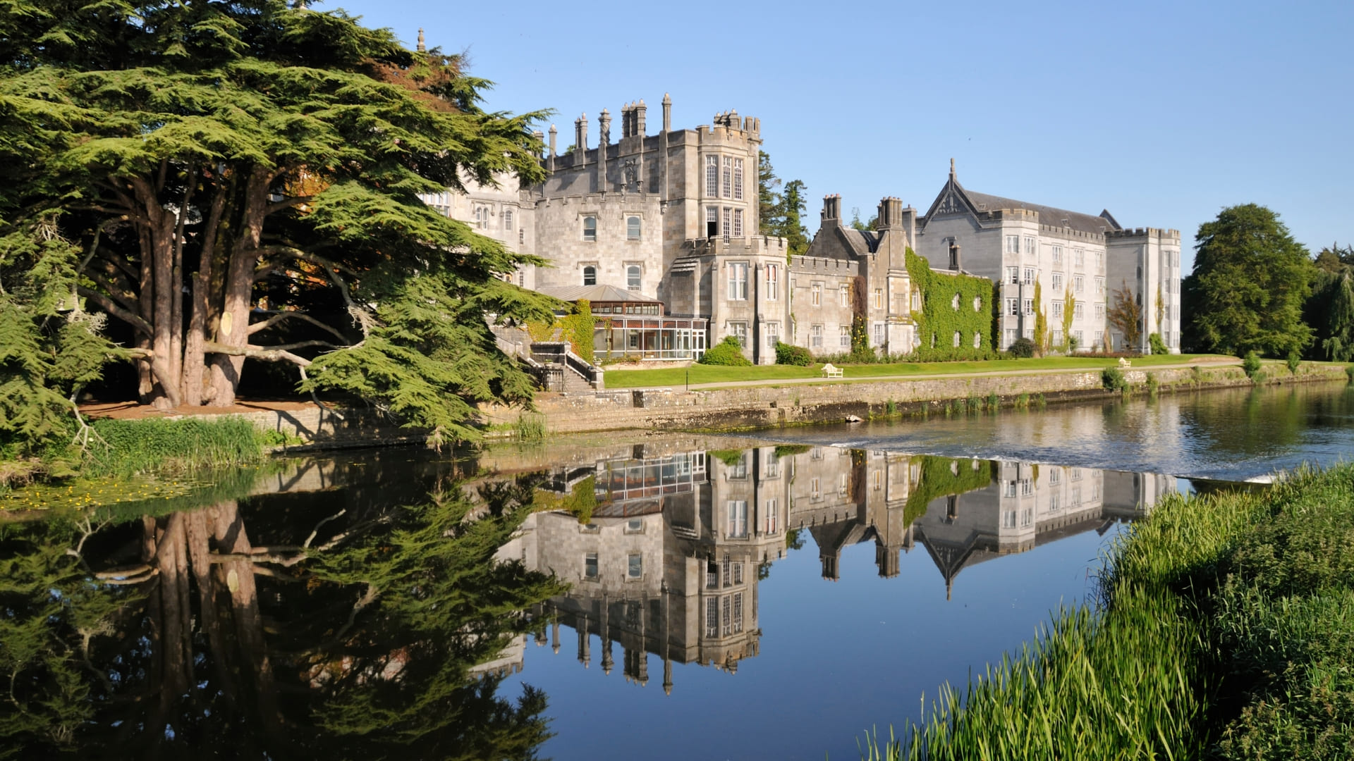 Historic Irish castle reflected on a calm lake, featured on the women-only Ireland itinerary.